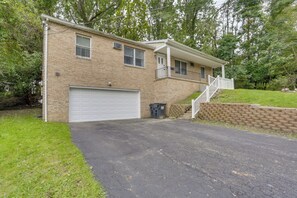 A two-story house with a garage, a front porch, and a brick exterior.