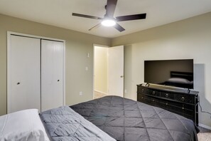 A bedroom with a bed, a ceiling fan, a TV on a dresser, and a closet. - Youngstown Home Near Fellows Gardens & Lake Milton (Youngstown)