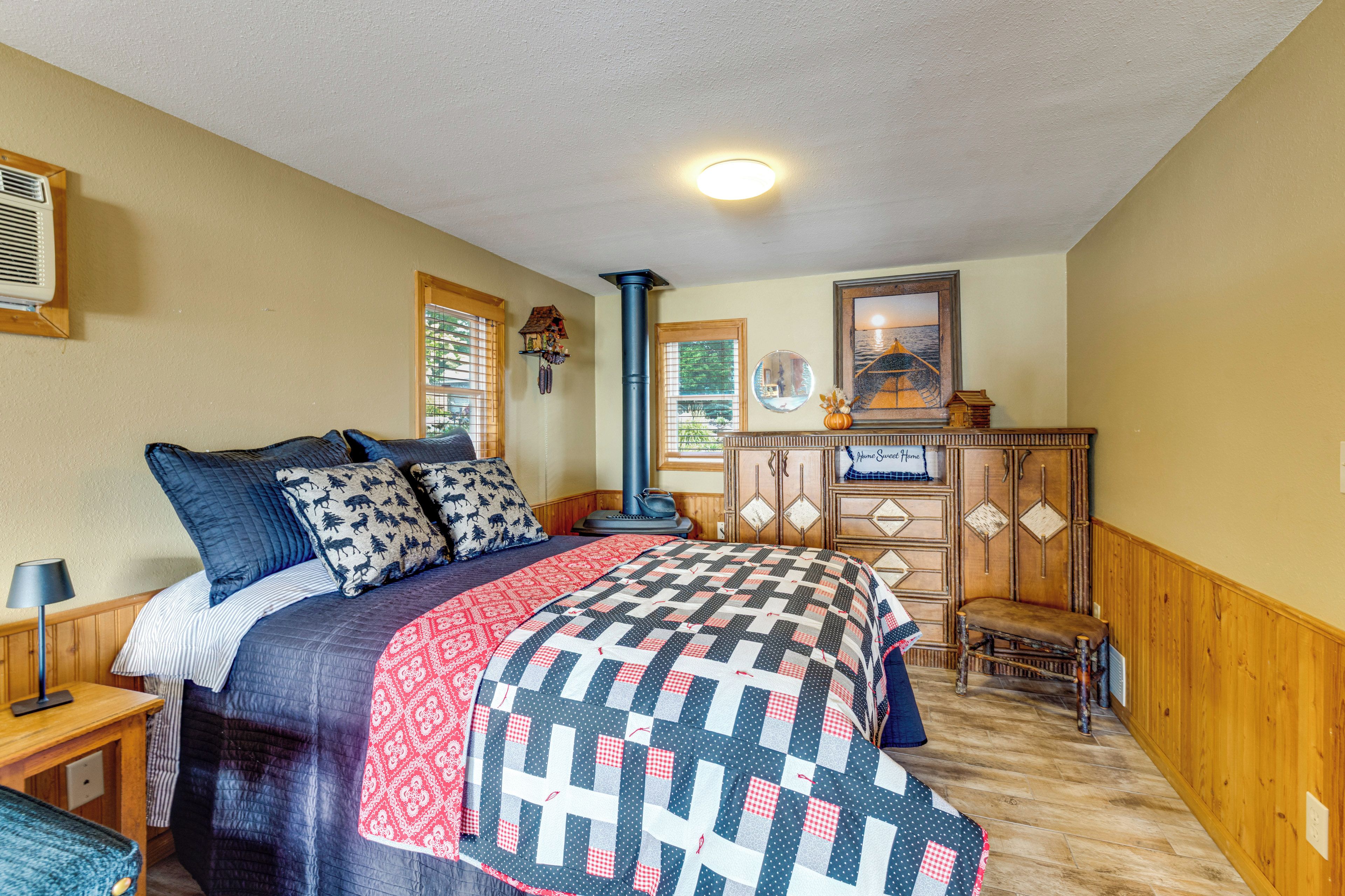 A bedroom with a bed, a dresser, a window, and a ceiling light.
