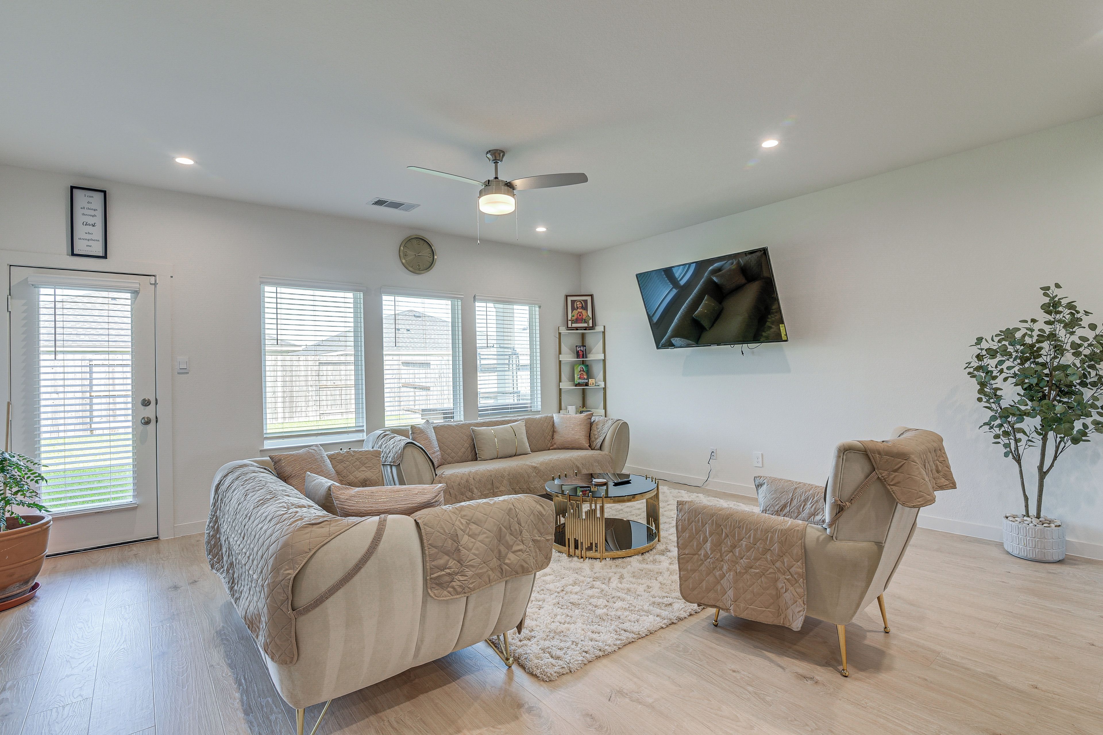 Una sala de estar con un sofá modular, una mesa de centro y un televisor montado en la pared.