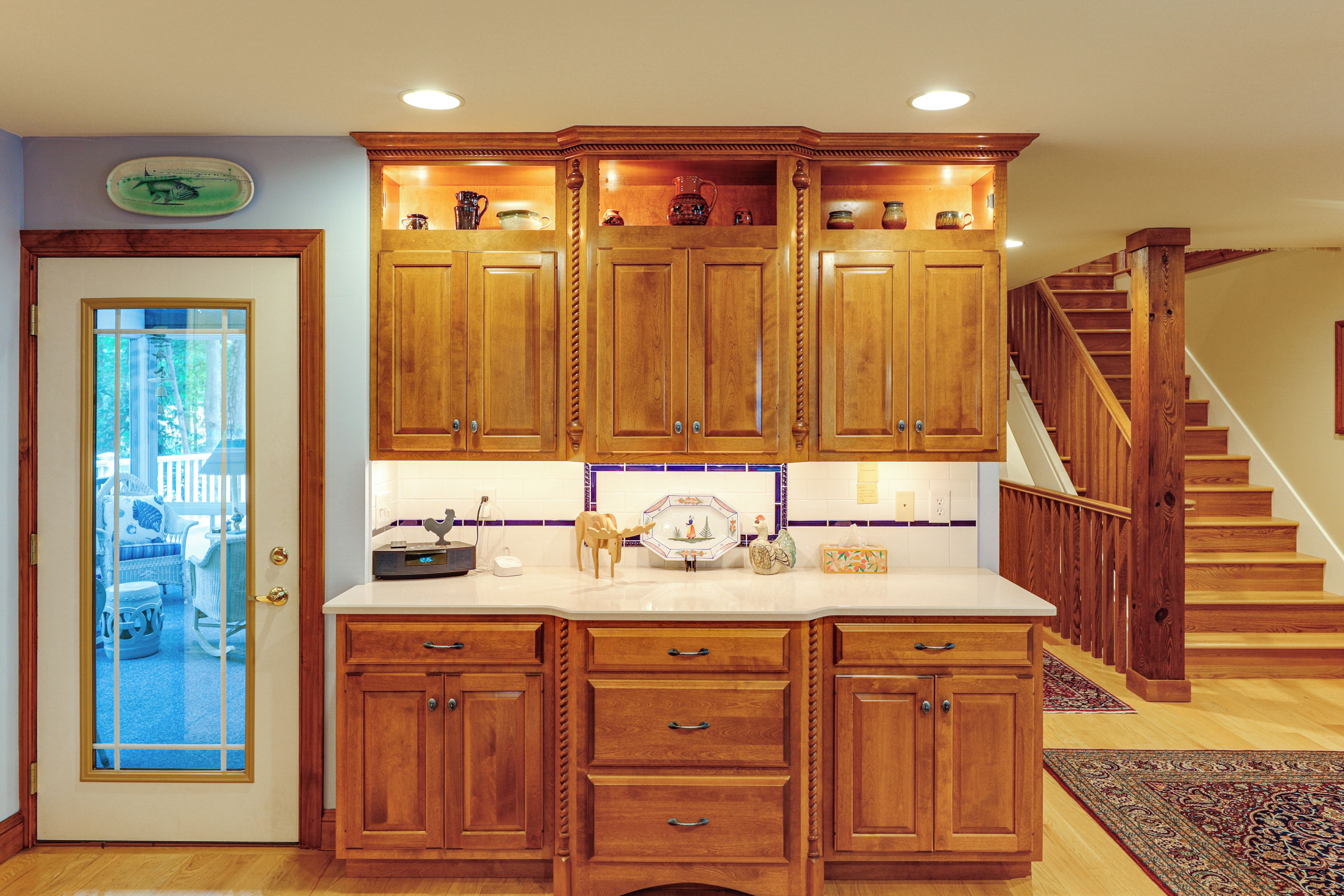 A kitchen with wooden cabinets, a white countertop, and a built-in stove.
