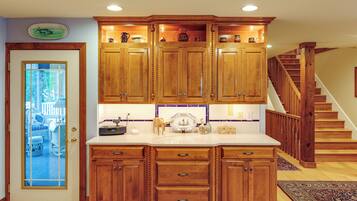 Una cocina con gabinetes de madera, una encimera blanca y una estufa integrada.
