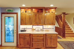 A kitchen with wooden cabinets, a white countertop, and a built-in stove. - Walk to Beach! 7BR Group Retreat in Bethany Beach (Bethany Beach)