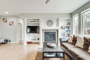 A living room with a fireplace, a sofa, a coffee table, and a TV. - 5,000 Sq Ft Luxury Mansion (Erie)
