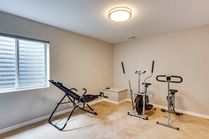 A room with a ceiling fan, a standing exercise bike, and a stationary bike. - 5,000 Sq Ft Luxury Mansion (Erie)