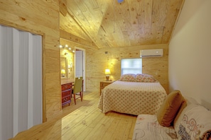 Un dormitorio con cama, mesita de noche, lámpara, cómoda y espejo.