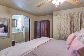 A bedroom with a bed, a wooden wardrobe, a mirror, and a ceiling fan. - Walk to Beach & Dock! Lake Texoma Family Getaway (Kingston)
