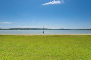 Un champ verdoyant avec une étendue d’eau calme et une rive lointaine.