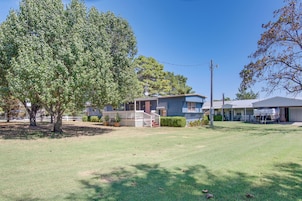 A residential property with a large lawn, a house with a porch, and a garage.