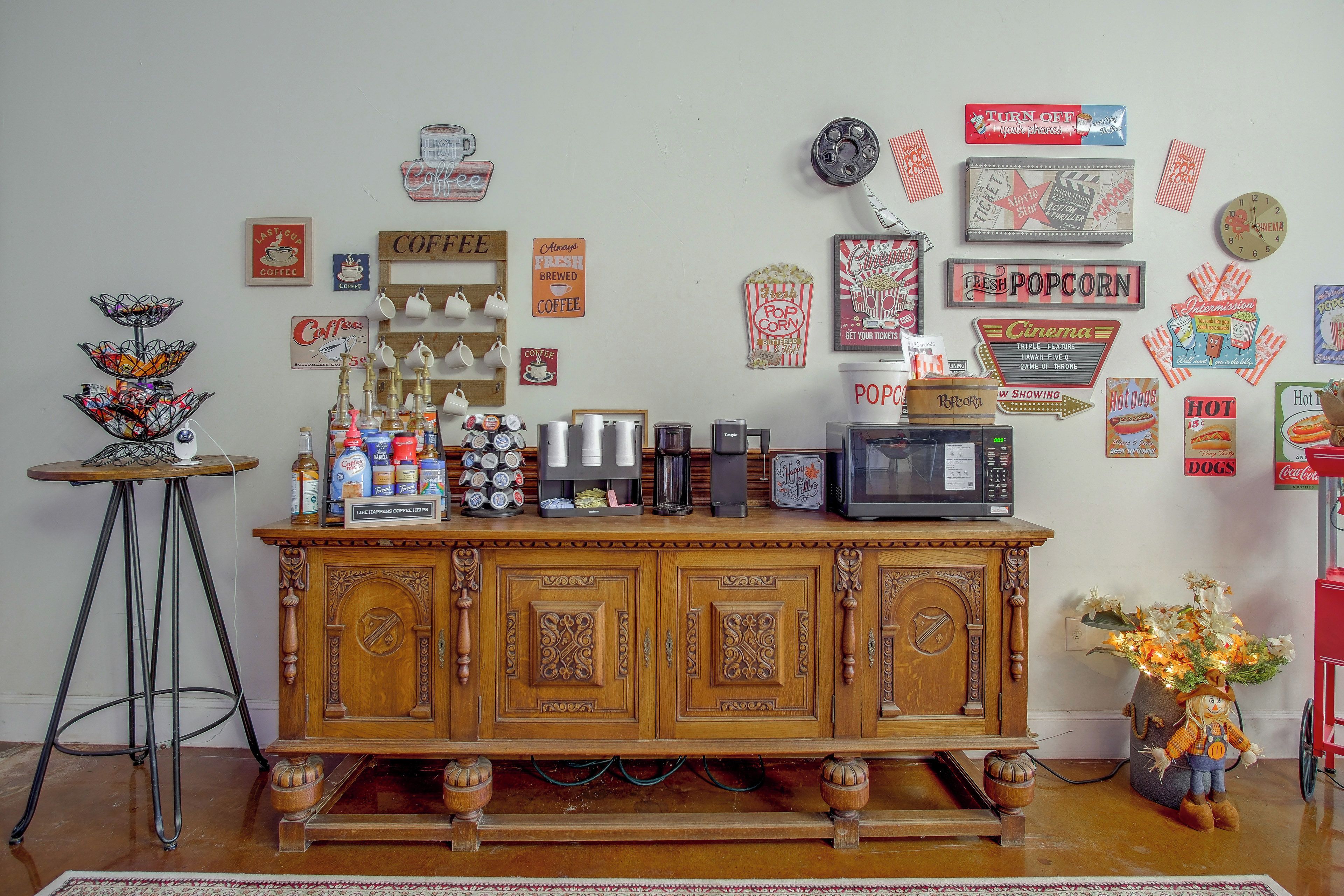 A coffee station with various coffee machines and cups, a popcorn machine, and a vintage television.