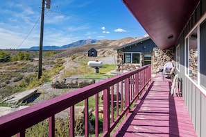 A wooden deck with a stone building in the background. - ATV Adventures & Private Pond! Marysvale Retreat (Marysvale)