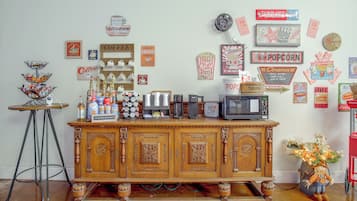 A coffee station with a variety of coffee makers and a popcorn machine.