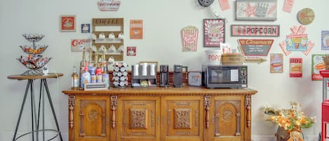 A coffee station with a variety of coffee makers and a popcorn machine.