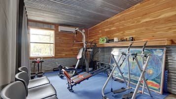 A gym with exercise equipment, a window, and a map on the wall.