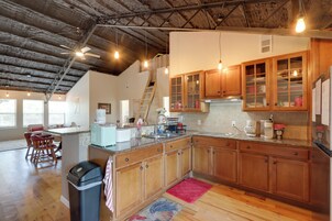 Una cocina amplia con armarios de madera, encimera de granito y vistas al área de estar.