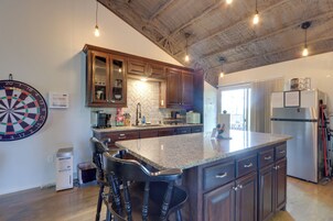 Una cocina con una isla central, armarios de madera y un dardo en la pared.