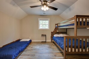 A room with two bunk beds, a ceiling fan, a window, and a small table. - Home Near Kentucky Lake & Paris Landing! (Buchanan)