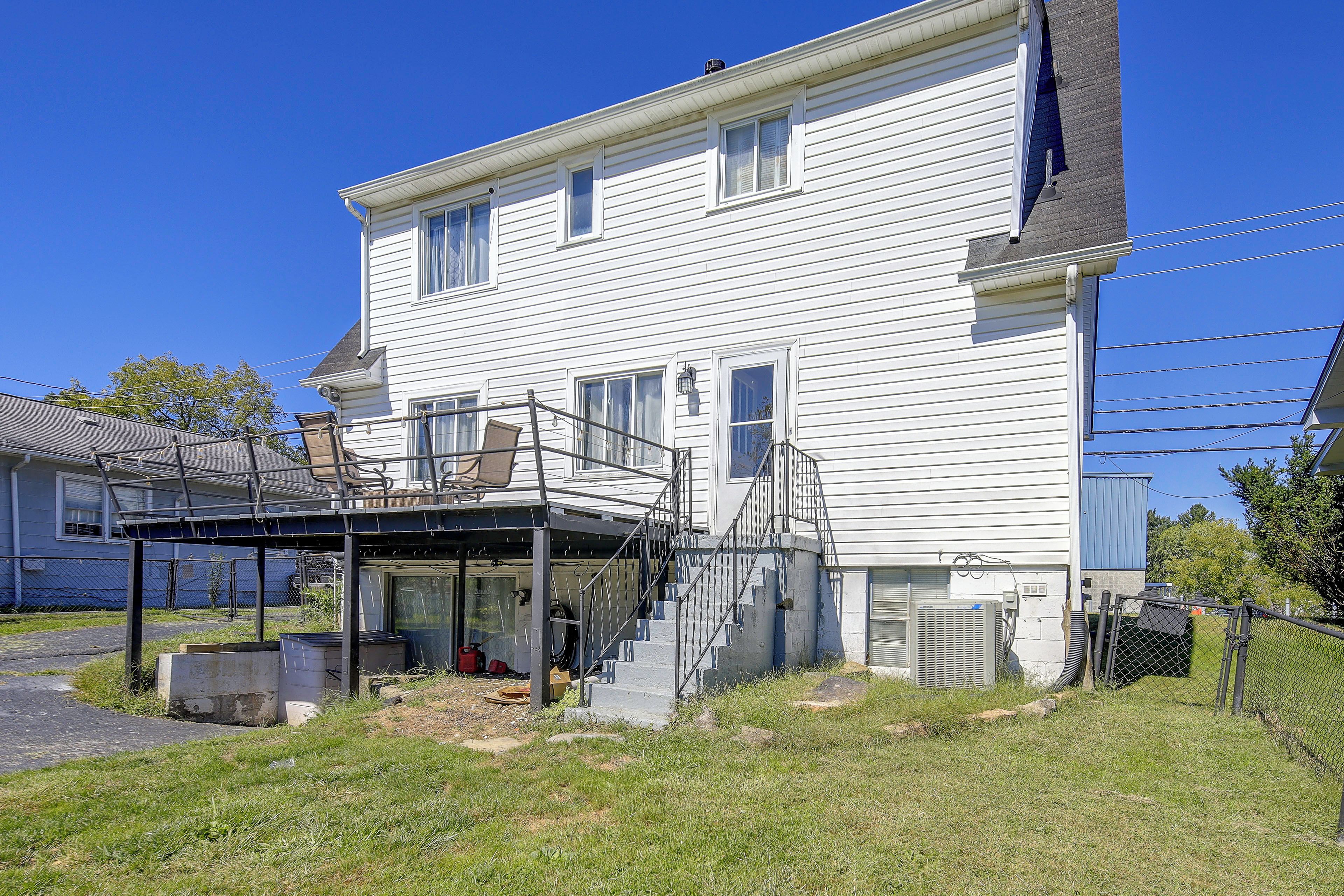 A two-story house with a covered porch and a small staircase leading to the upper floor.