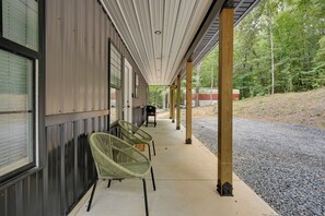 A covered outdoor area with two wicker chairs and a concrete pathway leading to a building. - Walk to Lake & Paris Landing State Park! Quiet Gem (Buchanan)