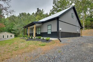 A modern building with a sloped roof, a covered porch, and a gravel driveway. - Walk to Lake & Paris Landing State Park! Quiet Gem (Buchanan)