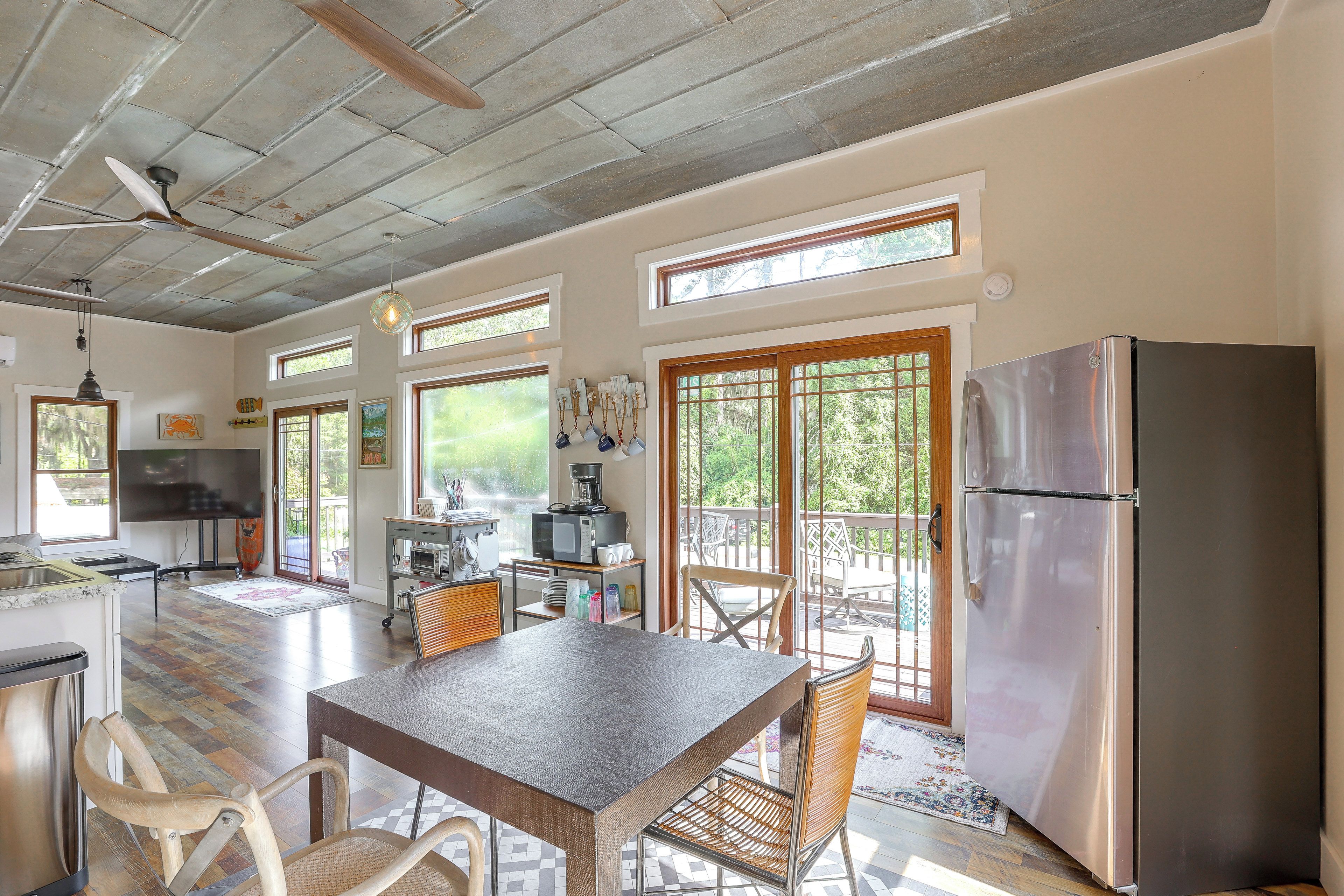 A spacious kitchen with a large island, a refrigerator, and a dining area with chairs.