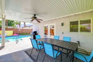 A covered patio area with a pool, a table with chairs, and a ceiling fan. - 3 Mi to Downtown! Sauna & Pool in Palm Springs (Palm Springs)