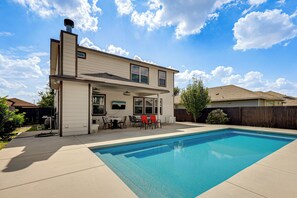 A two-story house with a swimming pool, a patio with outdoor furniture, and a wooden fence. - Hot Tub & Patio! Family Escape, 7 Mi to Seaworld (San Antonio)