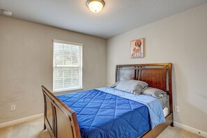 A bedroom with a bed, a window with blinds, a ceiling light, and a wall-mounted picture. - Hot Tub & Patio! Family Escape, 7 Mi to Seaworld (San Antonio)