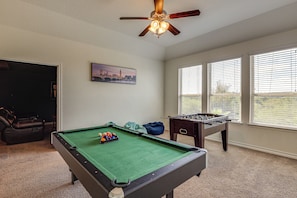 A room with a pool table, a foosball table, and a ceiling fan. - Home Theater & Game Room! 7BR San Antonio Retreat (San Antonio)