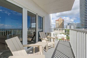 A balcony with two chairs and a table, overlooking a cityscape with high-rise buildings. - 1 Block to Sand! Ocean-view Retreat w/ Pool Access (Fort Lauderdale)
