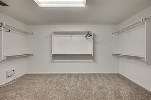 Una habitación con piso alfombrado, paredes blancas e iluminación en el techo.