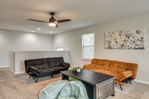 A living room with two sofas, a coffee table, a ceiling fan, and a painting on the wall. - Private Pool & Hot Tub: San Antonio Home (San Antonio)