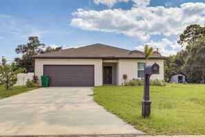 A single-story house with a garage, a mailbox, and a small shed in the yard. - Port St. Lucie Home on Florida's Treasure Coast (Port Saint Lucie)