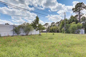 A grassy field with scattered flowers, a white fence, and trees in the background. - Port St. Lucie Home on Florida's Treasure Coast (Port Saint Lucie)