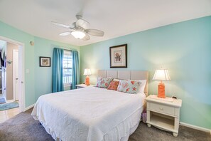 A bedroom with a bed, two bedside tables, a ceiling fan, and a window with curtains. - 5 Mi to Beach! Gulf Shores Condo w/ Pool & Hot Tub (Gulf Shores)