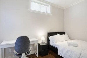 Une chambre à coucher avec un lit, un bureau et une chaise.