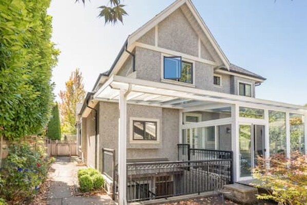 A two-story house with a covered patio area.