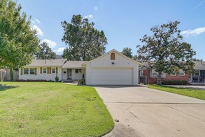 A residential house with a front yard, a garage, and a driveway. - Charming Tulsa Home Near Lafortune Park (Tulsa)