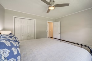 A bedroom with a bed, a ceiling fan, and two doors. - Charming Tulsa Home Near Lafortune Park (Tulsa)