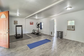 A spacious room with a treadmill, exercise mat, and a door leading to another area. - Private Workout Studio & Fenced Yard! Tulsa Escape (Tulsa)