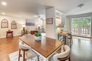 A spacious dining area with a wooden table and chairs, a potted plant, and a view of the outdoors through a glass door. - Private Workout Studio & Fenced Yard! Tulsa Escape (Tulsa)
