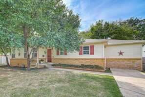 A single-story house with a brick foundation, a front porch, and a tree in the yard. - Private Workout Studio & Fenced Yard! Tulsa Escape (Tulsa)