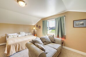 A bedroom with a bed, a sofa, a window with curtains, and a lamp. - Couples Retreat 4 Mi to Dtwn! Gateway to Glacier (Columbia Falls)