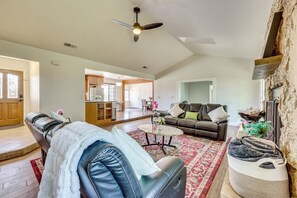 A spacious living room with a leather sofa, a coffee table, and a fireplace. - Private Pool! Charming Clovis Escape (Clovis)