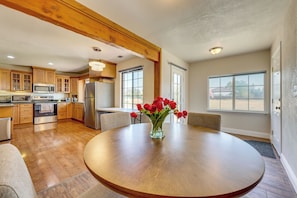 A spacious kitchen with modern appliances, a dining area with a wooden table and chairs, and large windows providing natural light. - Private Pool! Charming Clovis Escape (Clovis)