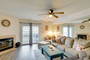 A living room with a sofa, a coffee table, a fireplace, and a ceiling fan. - Bayfront Haven w/ Boat Dock! 4 Mi to Bethany Beach (Ocean View)