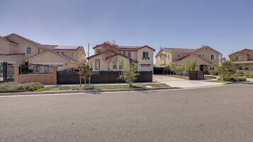A residential street with houses featuring a uniform architectural style, a clear sky, and a well-maintained road.
