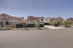 A residential street with houses featuring a uniform architectural style, a clear sky, and a well-maintained road.