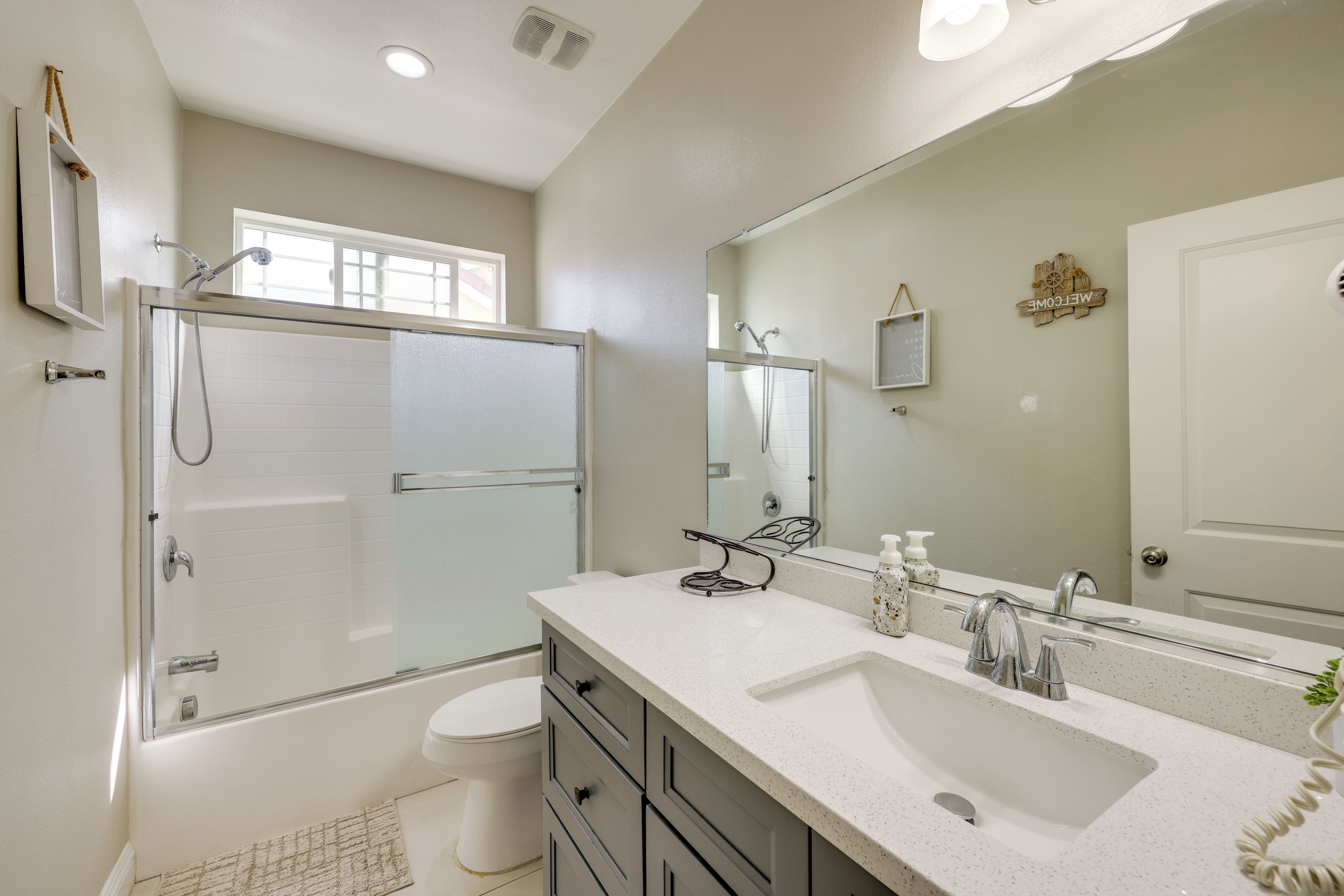 Une salle de bain moderne avec une douche à parois de verre, un meuble-lavabo à deux vasques et un grand miroir.