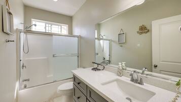 Une salle de bain moderne avec une douche à parois de verre, un meuble-lavabo à deux vasques et un grand miroir.